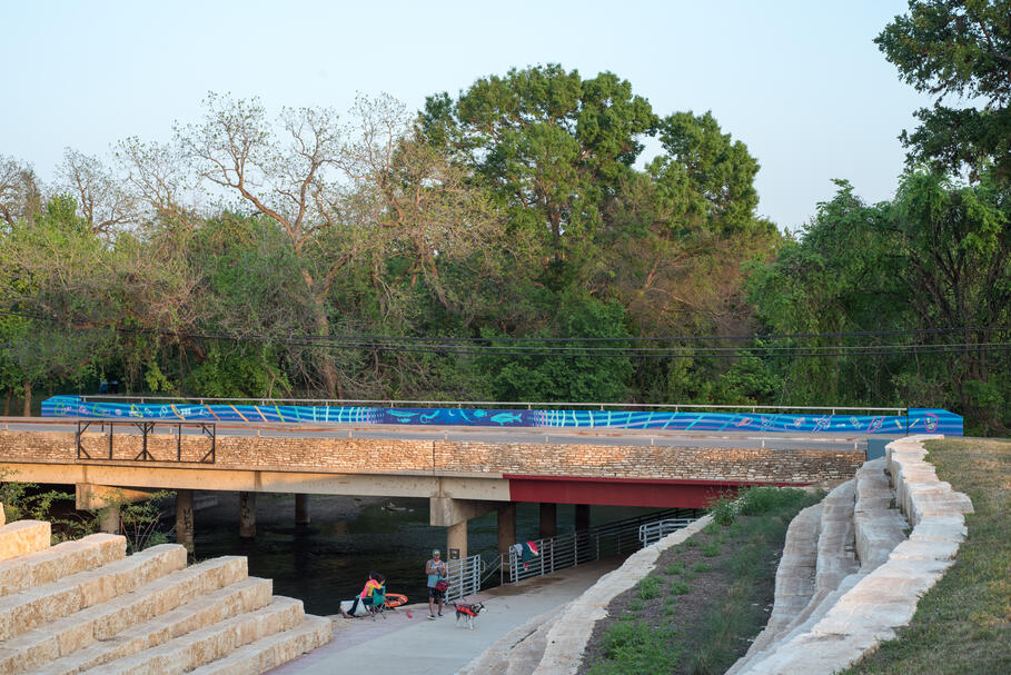 City of San Marcos dual nonverbal litter prevention mural commission over the San Marcos River, 2021